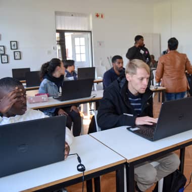 Classroom of young students working on laptops.